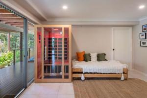 ein Schlafzimmer mit einem Bett und einem Balkon in der Unterkunft Casa Del Lago - Oceanstays - Lakehouse in Yamba