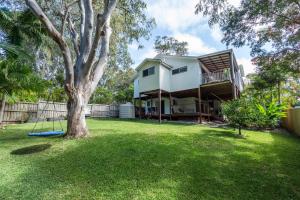 ein Haus mit einem Baum und einer Schaukel in einem Hof in der Unterkunft Casa Del Lago - Oceanstays - Lakehouse in Yamba + 32 Fotos