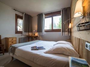 a bedroom with a bed with two books on it at Appartement 3 pièces avec Balcon et Wi-Fi proche piste à Courchevel - FR-1-575-3 in Courchevel