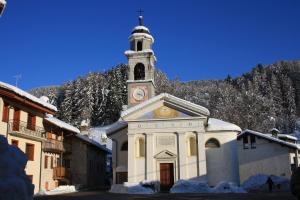 FallerにあるAlbergo Diffuso Fallerの時計塔のある小さな白い教会