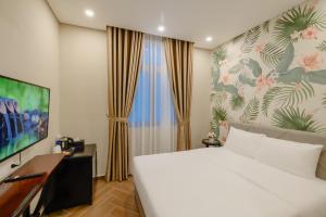 une chambre avec un grand lit blanc et une télévision dans l'établissement Tropical Sea Phu Quoc non-sleep, à Duong Dong