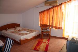 a bedroom with a bed and a chair and a window at Vila Bucura 19 A in Venus