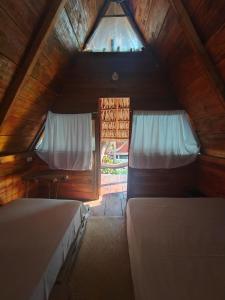 a attic bedroom with two beds and a window at Eco Cabañas Keiki Kai in Sipacate