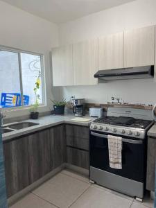 a kitchen with a stove and a sink at Casa Brigitte in Cancún