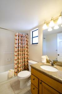 a bathroom with a toilet sink and a shower curtain at Park Shore Resort by Sunstream in Naples
