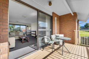 a room with a balcony with a table and chairs at Anchorbell Apartments Merimbula in Merimbula