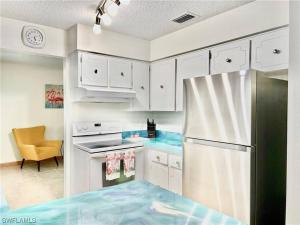 a kitchen with white cabinets and a refrigerator at Beautiful 3 Bed House with pool in North Fort Myers