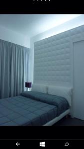 una camera con un grande letto con testiera bianca di B&B Numero Uno a Bisceglie