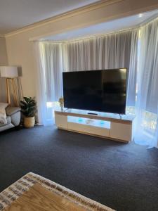 a living room with a large flat screen tv at Lbarza Charming & Convenient 3BR Home close to Hospitals & Sporting Grounds in Shepparton