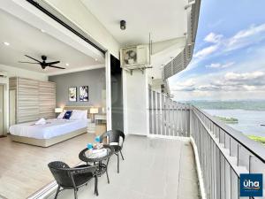 a bedroom with a balcony with a bed and chairs at Encorp Marina Puteri Harbour by RR JBcity in Nusajaya