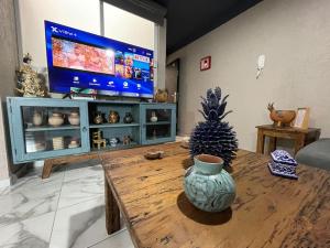 a living room with a table and a tv at Departamento Vista Lago de Pátzcuaro in Pátzcuaro