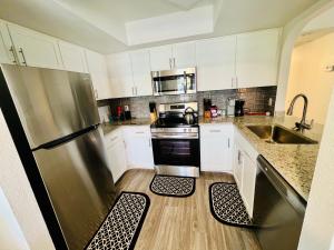 a kitchen with a stainless steel refrigerator and wooden floors at Cute 2 Bedroom 2 Bath 2 mile Strip5 in Las Vegas