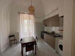 a kitchen with a table and a sink and a table and chairs at Giovinazzo Suite Antico Portale in Giovinazzo +6 photos