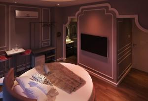a living room with a tv in a purple room at Sakura Hotel Thủ Đức in Ho Chi Minh City