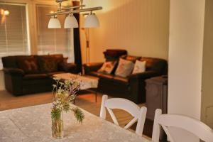 a living room with a table with a vase of flowers on it at Oksfjordhjem in Mettevoll