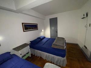 Un dormitorio con dos camas y una mesa dentro. en CASA ROMÁN Departamento en Providencia para 3 personas, en Santiago 47 fotos más