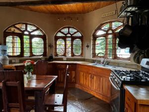 a kitchen with a table and a stove and windows at Magical Malewa Retreat in Naivasha
