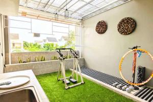 a room with a gym with a treadmill and a mirror at Cottonwood Villa Kuantan Jogja - Pool Netflix Gym in Ngabean