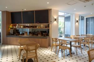 a restaurant with tables and chairs and a counter at Hotel 88 Kedoya Jakarta in Jakarta
