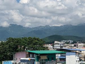 a view of a city with mountains in the background at Dorm Hub in Dehradun