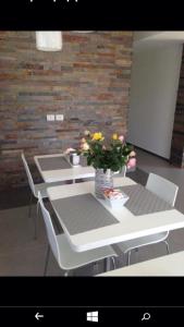 une table et des chaises avec un vase de fleurs. dans l'établissement B&B Numero Uno, à Bisceglie