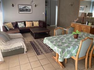 ein Wohnzimmer mit Tisch und Couch in der Unterkunft 94 on Main in Kiddʼs Beach