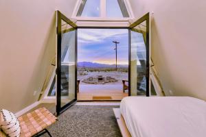 a bedroom with a bed and a balcony with a view at Stardust Big Bend Luxury A-Frame#1 with a fab view in Terlingua
