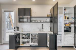 a kitchen with stainless steel appliances and gray cabinets at Stardust Big Bend Luxury A-Frame#1 with a fab view in Terlingua