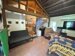 Una sala de estar con dos camas y un televisor de pantalla plana. en sea monkey diving homestay, en Isla Verde