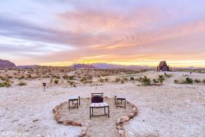 a table and chairs in the middle of the desert at Stardust Big Bend Luxury A-Frame#1 with a fab view in Terlingua