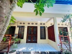 una casa con una puerta de entrada acogedora en Mawar Bungalow, en Gili Trawangan