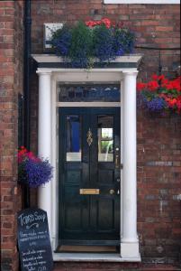 a black door with flowers on a brick building at Haydens B&B in Rye
