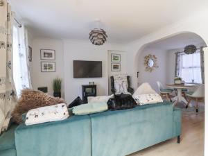 a living room with a blue couch with pillows at Ted's Cottage in Skipton