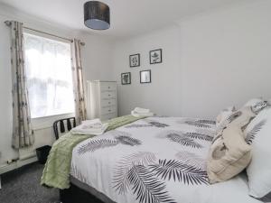 a bedroom with a bed with a black and white blanket at Ted's Cottage in Skipton