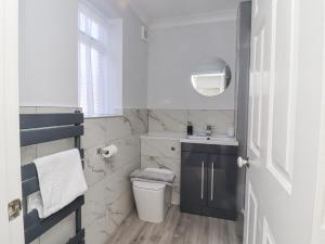 a white bathroom with a sink and a toilet at Ted's Cottage in Skipton +26 photos