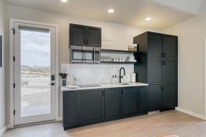 una cucina con armadi neri e una grande finestra di Stardust Big Bend Luxury A-Frame#10 with a fab view a Terlingua