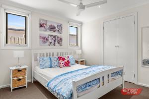 カウズにあるGoondiwindi Cowesのベッドと2つの窓がある寝室