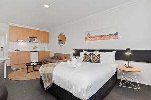 ein Schlafzimmer mit großem Bett und ein Wohnzimmer in der Unterkunft Perth Cbd Oasis Murray Street Studio in Perth