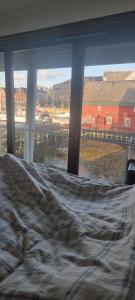 a bed in a bedroom with a view of a harbor at The Seaview Suite - Tromsø harbour! in Tromsø
