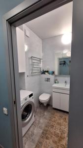 Un baño con lavadora y un inodoro. en Оскар, en Almaty 48 fotos más