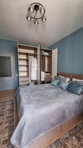Un dormitorio con una cama grande y una lámpara de araña. en Оскар, en Almaty
