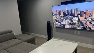 a living room with a couch and a flat screen tv at Modern West Coast Contemporary Suite in Vancouver