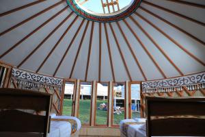 a yurt with two beds and a bunch of windows at Ethno complex Ala kush in Kaindy