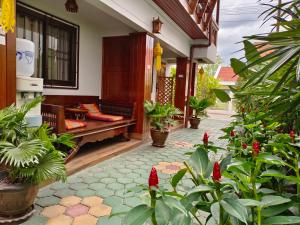 a patio with plants and a bench in a house at Aphilapa Residence in Chiang Mai