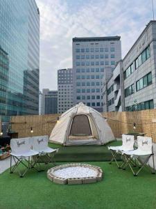 namiot, stoły i krzesła na polu trawy w obiekcie Holiday Home near Dongdaemun Myeongdong w Seulu