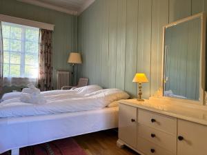 a bedroom with a large bed and a dresser with a mirror at Orkla Gjestebolig in Løkken +12 photos