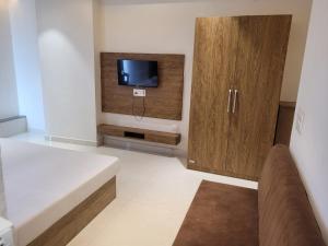 a small living room with a tv and a couch at Hotel Royal Vilas in Bharatpur