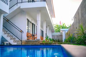 a swimming pool in front of a house at Rice Fera Guest House in Canggu