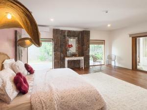 a bedroom with a large bed and a fireplace at Domaine Putu Bali - Havre de paix & Piscine Lagon in Petit Raffray