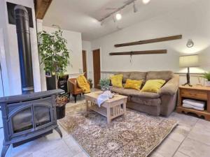 a living room with a couch and a fireplace at DancingBears- 8BR, 2 Hot Tubs, 2 Homes, Game Room, AC! in Killington